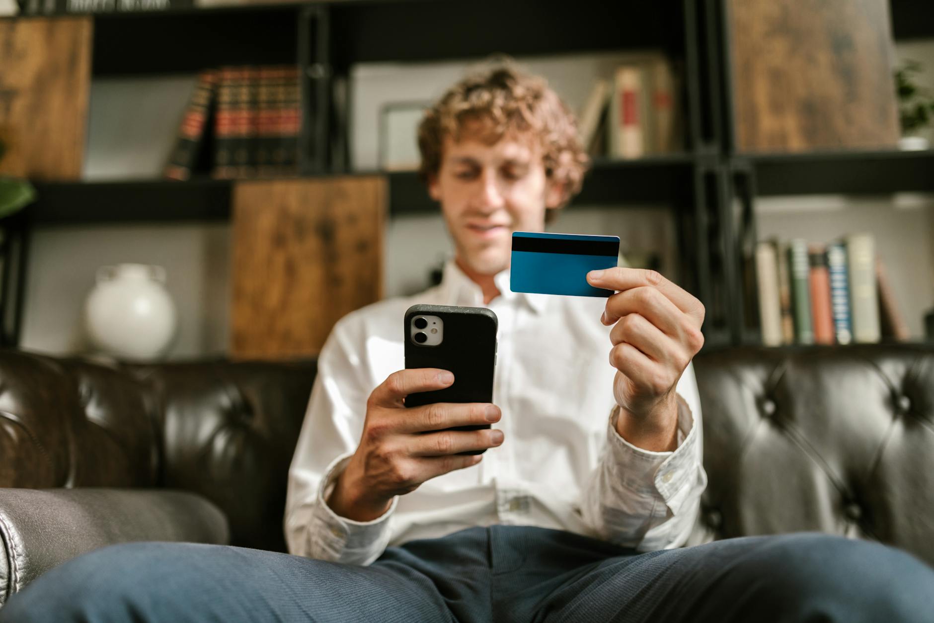 A person holding a credit card and phone for a credit security check.