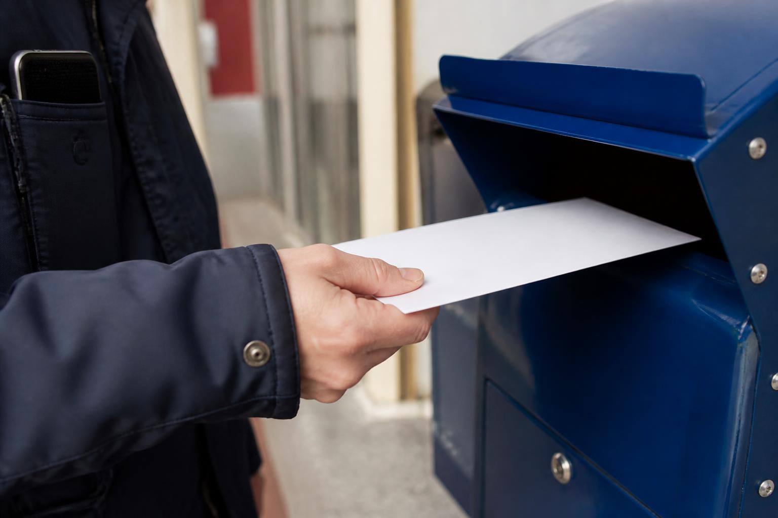 A taxpayer mailing a sealed envelope before the tax deadline.