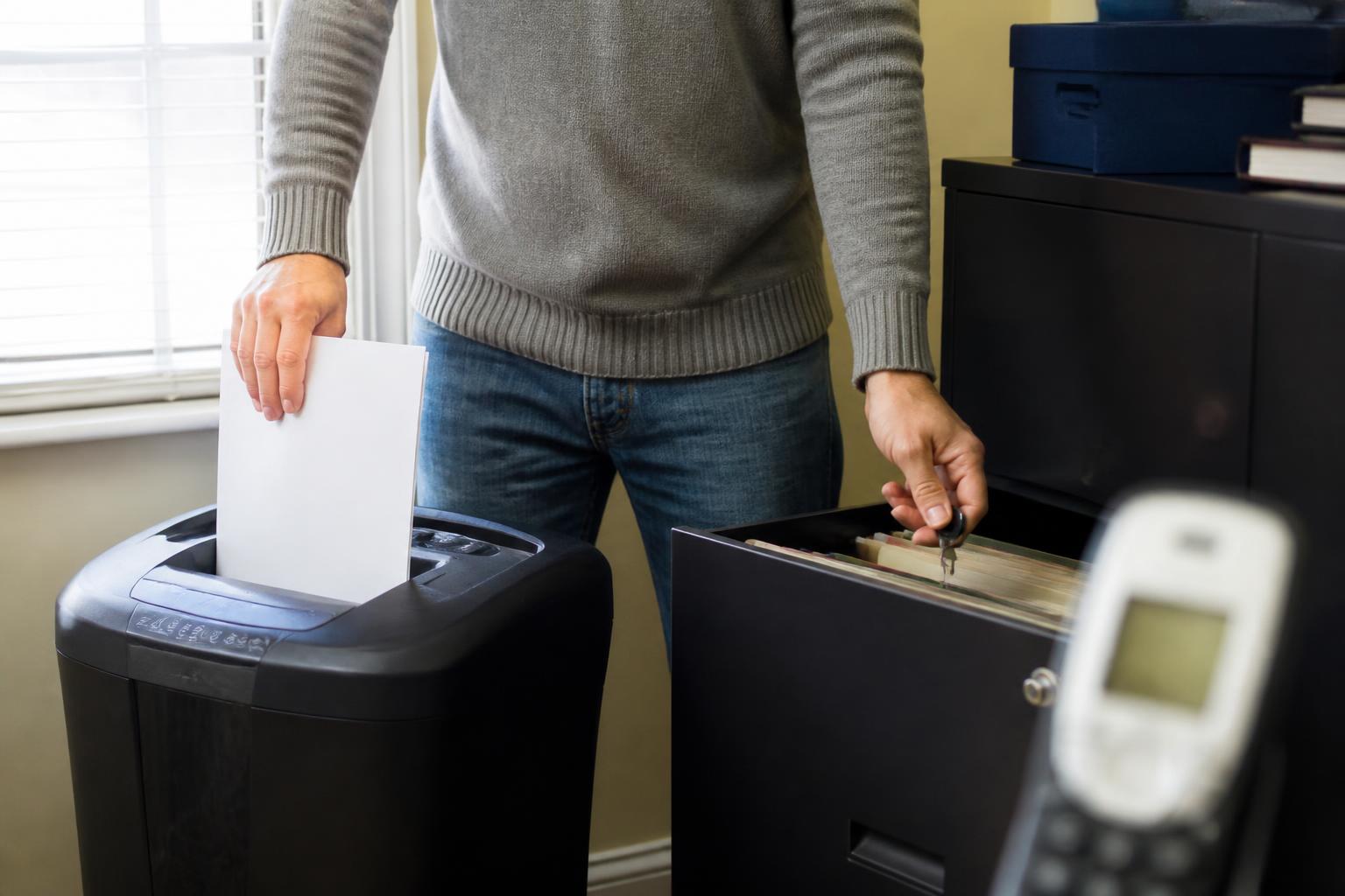 A person shredding tax mail and locking records during tax season.