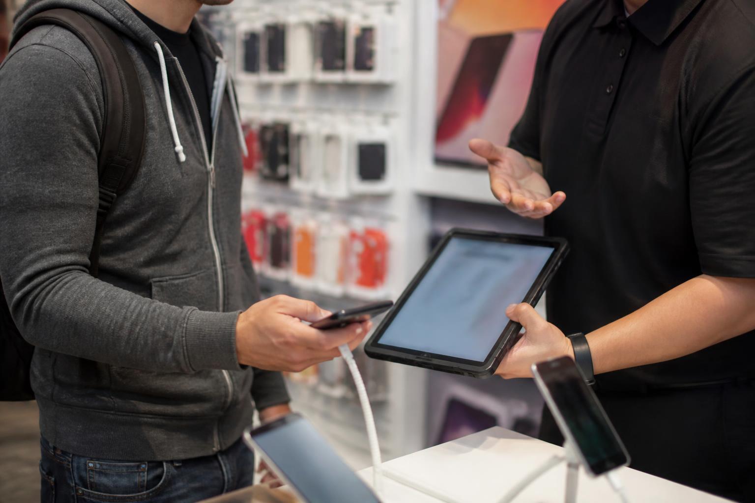 A customer comparing wireless plan details in a generic phone store.