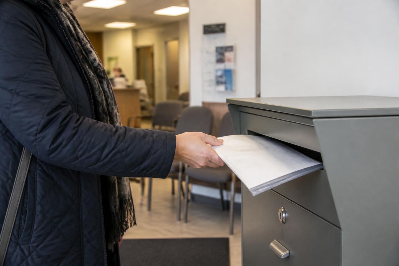 A taxpayer dropping sealed tax records at a tax-prep office.
