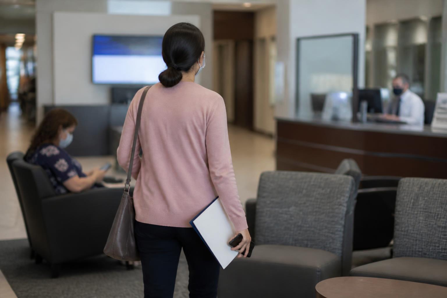 A saver walking toward a banker desk with a savings folder.