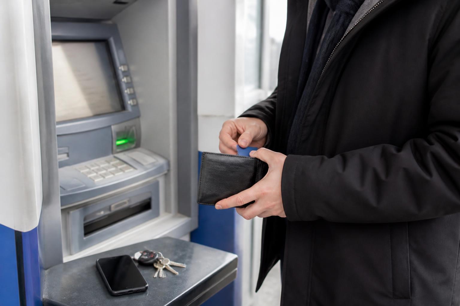 A person using an ATM during refund season planning.