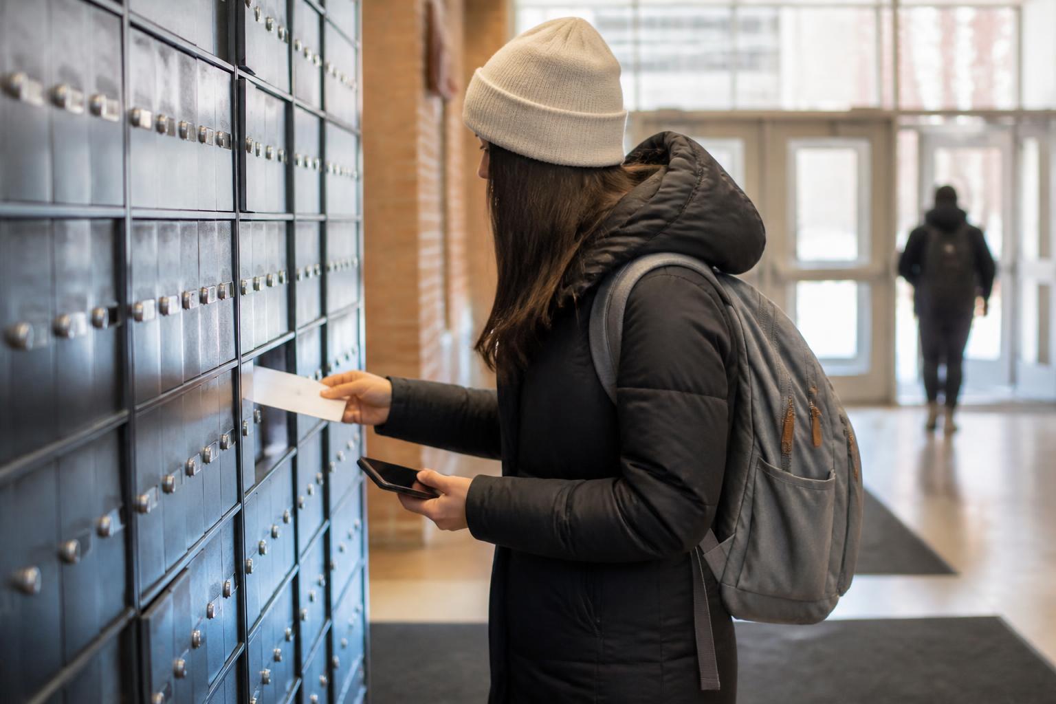 A borrower checking campus mail while setting a loan reminder.